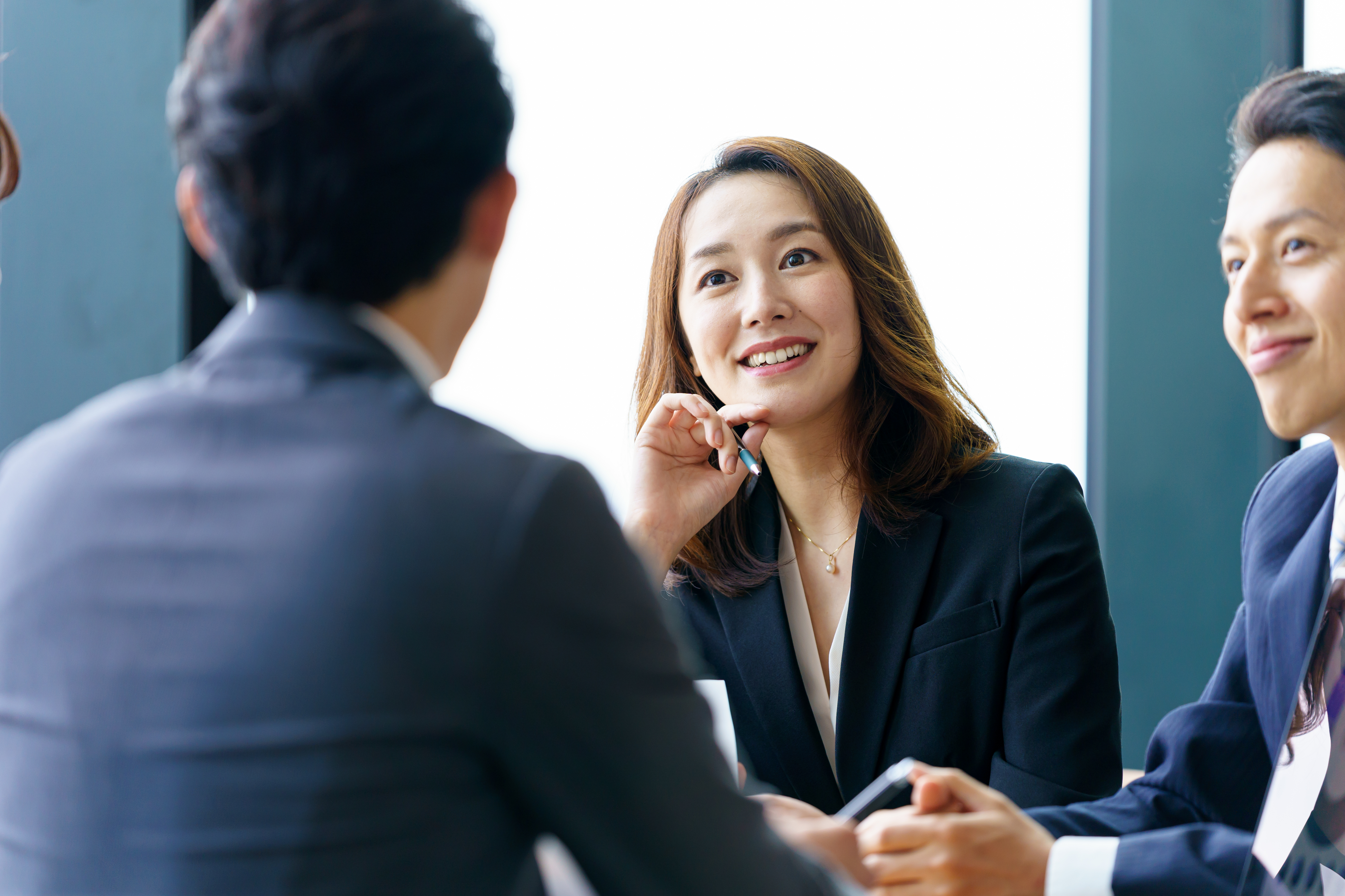 スーツを着た男女が会話をしている様子の画像